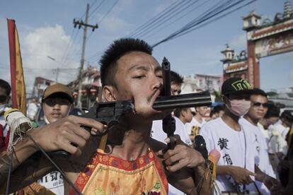 Un devoto chino del santuario Jui Tui muestra sus mejillas perforadas con pistolas durante el festival Vegetariano en Phuket.