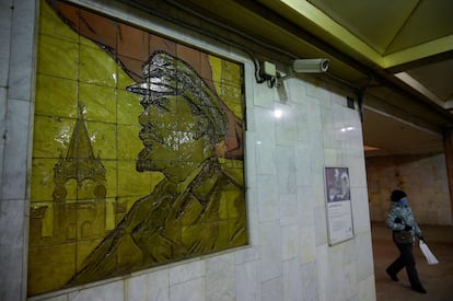 Una mujer pasa cerca de una cámara de seguridad situada junto a un mosaico de Lenin en una estación de metro de Moscú.