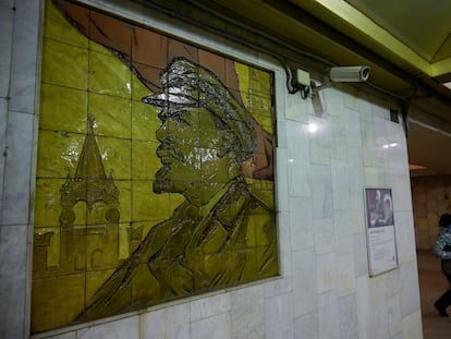 Una mujer pasa cerca de una cámara de seguridad situada junto a un mosaico de Lenin en una estación de metro de Moscú.