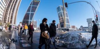 Peatones cruzan una calle en Plaza de Castilla en Madrid, este martes.