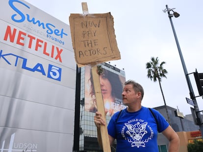 Screenwriter Travis Adam Wright, supporting the Screen Actors Guild, walks with a homemade sign in front of Netflix in Hollywood, California, USA, 25 September 2023.