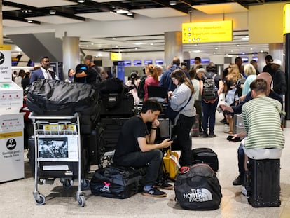 Varios pasajeros hacen cola en el mostrador de facturación de British Airways en el aeropuerto de Heathrow, este lunes.