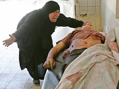 Una mujer llora ante el cadáver de su hijo, fallecido en el atentado de ayer en Bagdad.