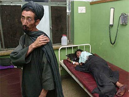 Shah Wali (izquierda) explica en un hospital de Kandahar las heridas sufridas por su esposa como consecuencia de la bomba estadounidense.