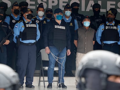 Former Honduran President Juan Orlando Hernandez, center in chains, is shown to the press in Tegucigalpa.