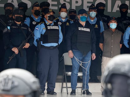 El expresidente de Honduras Juan Orlando Hernández rodeado de policías y esposado tras su detención este martes en Tegucigalpa.