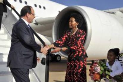 Fotografía facilitada por el gobierno sudafricano que muestra al presidente galo François Hollande (izda) junto a la ministra de Relaciones Internacionales y Cooperación, Maite Nkoana-Mashabane (dcha), a su llegada hoy a la base aérea de Waterkloof en Pretoria (Sudáfrica).