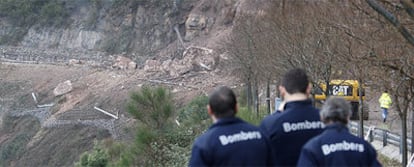 Un grupo de bomberos de la Generalitat, ayer, contemplando el desprendimiento en la zona de Els Degotalls de la montaña de Montserrat.