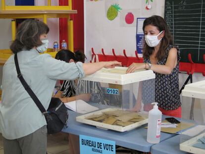 Una electora deposita su voto en un colegio electoral en Marsella, Francia, durante la segunda vuelta de las elecciones regionales.