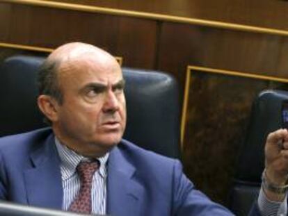 El ministro de Economía y Competitividad, Luis de Guindos, durante el pleno del Congreso de los Diputados que convalida hoy las últimas medidas de ajuste del Gobierno.