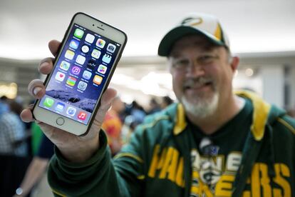 Un hombre muestra un tel&eacute;fono de Apple