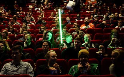 Un fan de Star Wars espera con su sable de luz para el inicio del estreno en Helsinki, Finlandia.