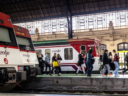 Varias personas pasaban el lunes junto a trenes de cercanías en la Estación del Norte de Valencia.