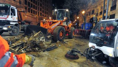 Los equipos de limpieza municipales retiran la pasada noche los restos de la 'cremà'.
