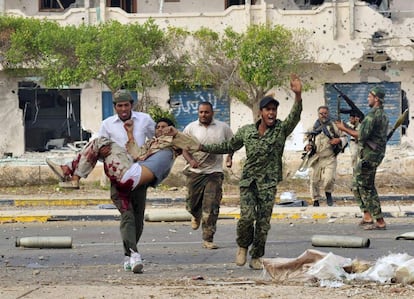 Combatientes del Consejo Nacional Transitorio evacuan a un compañero herido durante los combates en Sirte, el 19 de octubre.