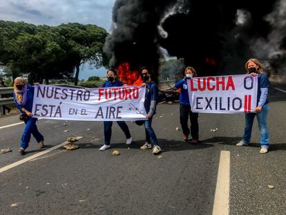 Varias trabajadoras se fotografían en el incendio provocado por parte de la plantilla de la factoría de Airbus de Puerto Real en la autovía CA-35 que da acceso a los puentes de la Bahía de Cádiz, como protesta por el cierre de la planta.