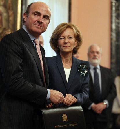 El ministro de Economía y Competencia, Luis de Guindos, sonríe junto a su antecesora en el cargo, Elena Salgado, durante la toma de posesión de su cartera en la sede de la calle Alcalá.
