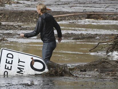 Phillip Harnsberger cruza una calle inundada por el lodo en Montecito, California, el 9 de enero.