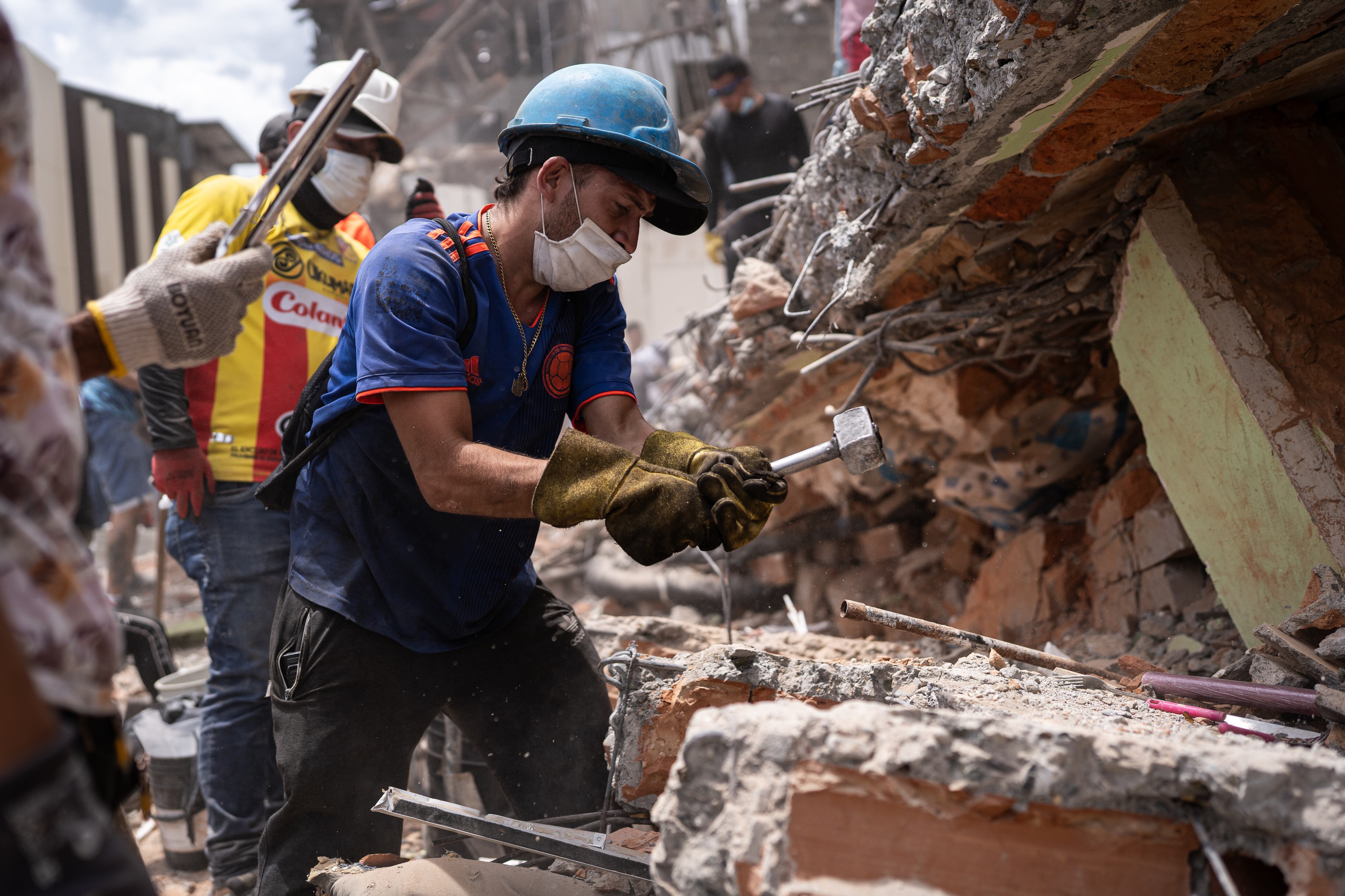 Un grupo de voluntarios trabajan en las ruinas de un edificio colapsado, en Pereira.
