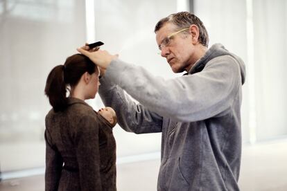 El escultor Ron Mueck retoca la obra 'Mujer con compra'