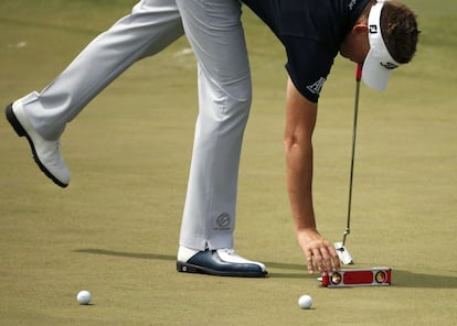 Ian Poulter de Inglaterra utiliza un nivel durante su ronda de práctica antes de los 2015 Masters en el Augusta National Golf Course en Augusta, Georgia.