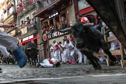 Los mozos corren ante los toros de la ganadería de José Escolar durante el tercer del encierro de San Fermín, este sábado.
