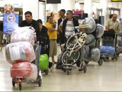 Viajeros hacen cola en el aeropuerto de Miami para viajar a Cuba.
