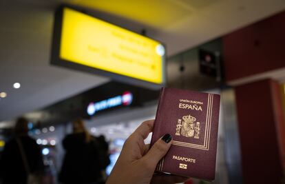 Una mujer sostiene su pasaporte español en el aeropuerto.