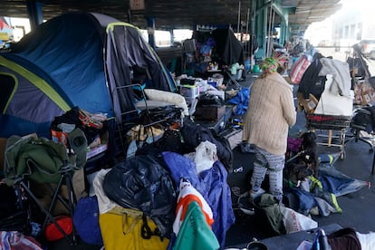 A woman gathers possessions to take before a homeless encampment was cleaned up in San Francisco, Aug. 29, 2023