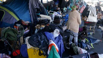 A woman gathers possessions to take before a homeless encampment was cleaned up in San Francisco, Aug. 29, 2023