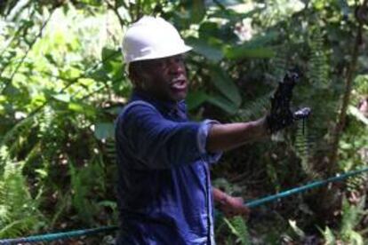 El actor estadounidense Danny Glover muestra su mano manchada de restos de petrleo durante su visita al rea donde oper Chevron-Texaco, en la zona de Aguarico 4, en la provincia de Sucumbos (Ecuador). Glover, que es adems un activista de derechos sociales, fue invitado por el gobierno ecuatoriano para comprobar insitu la contaminacin causada por la multinacional entre los a?os 1962 y 1990.