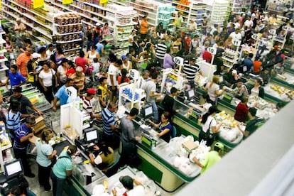 Un grupo de personas espera para poder comprar productos en un supermercado de San Crist&oacute;bal.