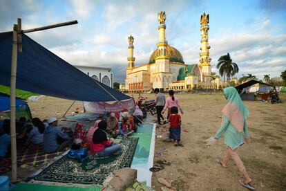 Un grupo de personas permanece en una tienda de campaña cerca de un centro de evacuación y de la mezquita de Mataram, en Tenggara, el 7 de agosto de 2018. 