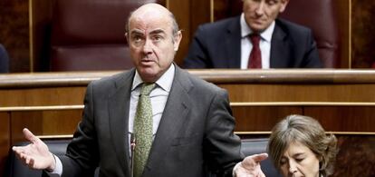 El ministro de Economía, Luis de Guindos, junto a la ministra de Agricultura, Pesca y Alimentación y Medio Ambiente, Isabel García Tejerina, durante una intervención en la sesión de control al Gobierno en el Congreso.