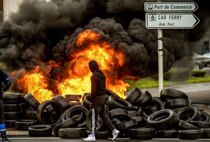 Un pescador de Boulogne (Francia) en la entrada bloqueada por neumáticos en llamas del puerto Boulogne-sur-Mer durante unas protestas.