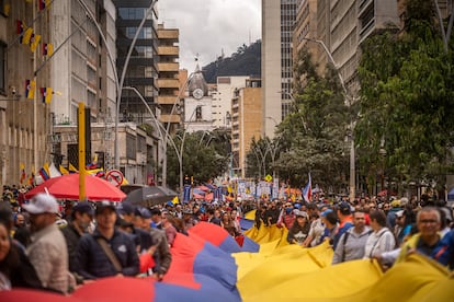 Cientos de personas avanzan por la carrera Séptima, en el centro de Bogotá. 