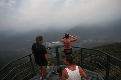 Tres personas observan este martes, el incendio cercano a la localidad de Pombriego (León).