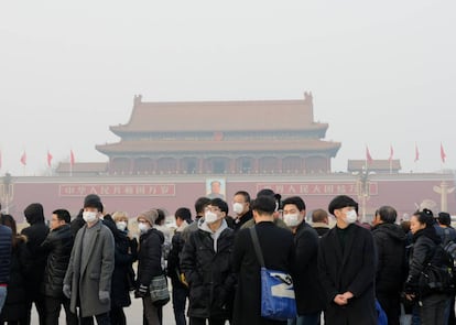 Un grupo de turistas llevan mascarillas para protegerse de la polución en la Plaza de Tiananmen, en Pekín (China), donde el nivel de polución es de 212 microgramos por metro cúbico.