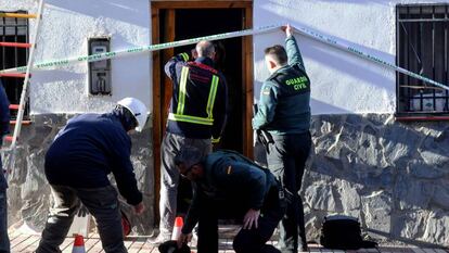Agentes de bomberos y de la Guardia Civil investigan en la vivienda de Dehesas Viejas en la que han fallecido tres personas. 