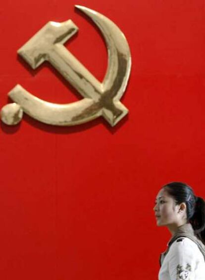 Una mujer pasa junto al emblema del Partido Comunista Chino  en el Museo Militar de Pekín.