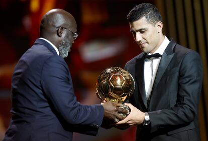 Manchester City and Spain midfielder Rodrigo receives the 2024 Ballon d'Or from former Liberian President and former player George Weah.