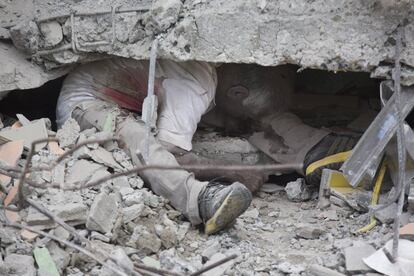 El cuerpo de un hombre bajo los escombros.