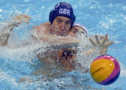 El británico Joseph O'Regan (izquierda) lucha con el rumano Cosmin Radu durante el partido de la fase de grupos de waterpolo masculino.