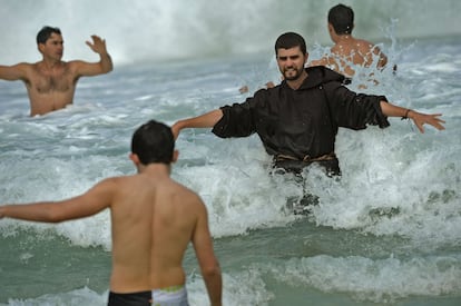 Río de Janeiro, Brasil, 28 de julio de 2013. Un monje franciscano se baña en la playa de Copacabana tras la misa de clausura del Papa Francisco en su visita a Brasil por la celebración de la Jornada Mundial de la Juventud. Dos millones de personas apoyaron su mensaje de cambio reforzándole frente a los conservadores de la curia. El pontífice, además, sorprendió a los periodistas en el vuelo de regreso de Río de Janeiro, cuando aceptó a someterse durante una hora y 20 minutos a las preguntas de los periodistas. “Quién soy yo para juzgar a los gais?”, fue una de sus respuestas.