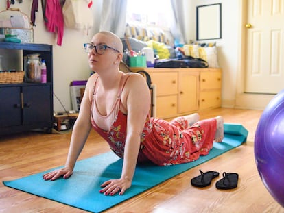 Una mujer de 30 años con cáncer de mama practica yoga en su casa.