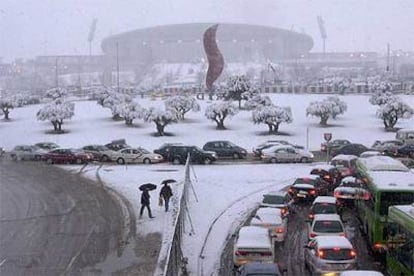 La avenida de los Arcentales, cubierta ayer por un manto de nieve. Al fondo, el estadio de La Peineta y el logotipo de la candidatura olímpica de Madrid.