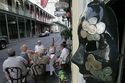 Clientes del restaurante Patout's, en el Barrio Francés de Nueva Orleans, charlan el viernes bajo la presencia de una máscara del carnaval de Mardi Grass.