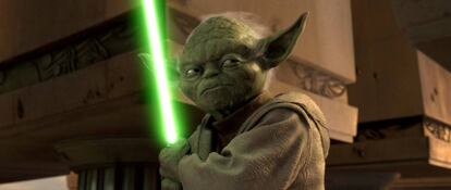 Yoda, personaje de La guerra de las galaxias, con su arma.