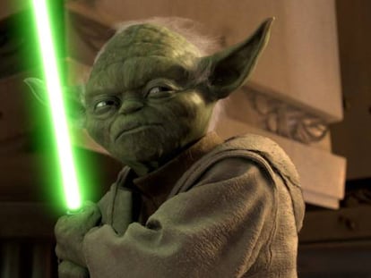 Yoda, personaje de La guerra de las galaxias, con su arma.