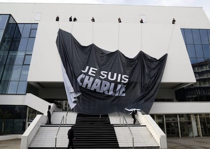 Varios operarios despliegan una gran lona en la que se lee "Je suis Charlie" (Yo soy Charlie), en la fachada del Palacio de Festivales de Cannes.